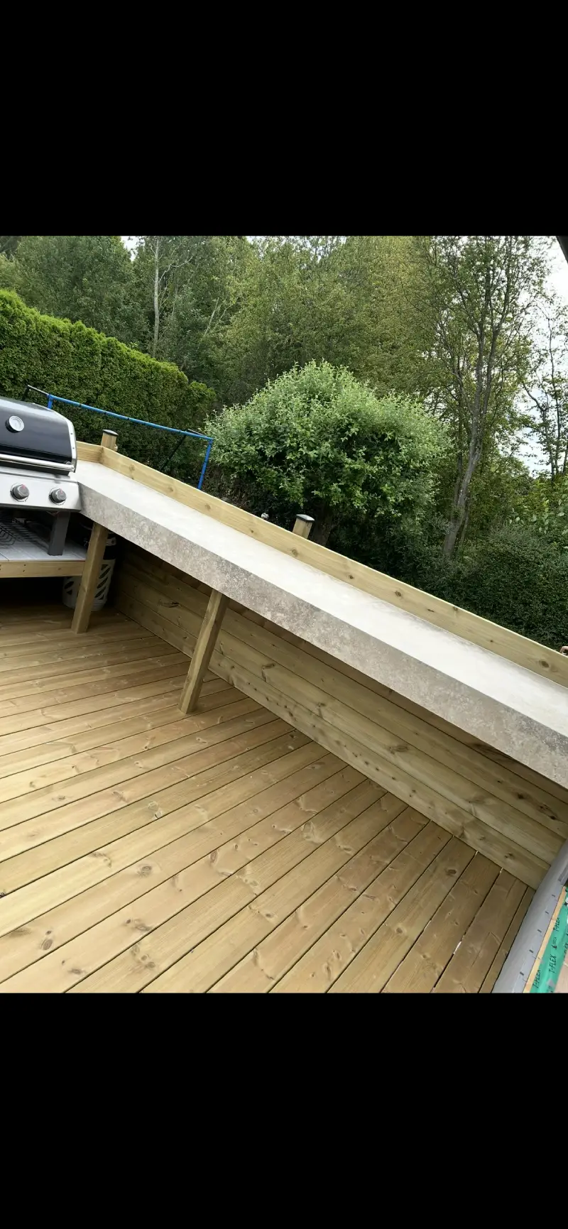 Bänkskiva i granitkeramik monterad vid grillplats, utförd av Mplattsättning AB.