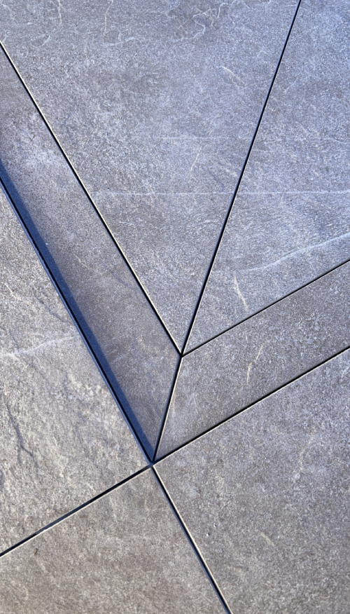 Närbild på golv och exakt skurna plattor. Arbetet utfört av Mplattsättning AB.